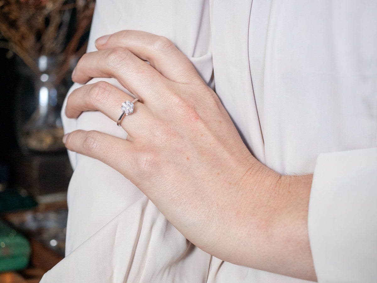 Anillo de compromiso moderno con flor de diamantes y oro blanco