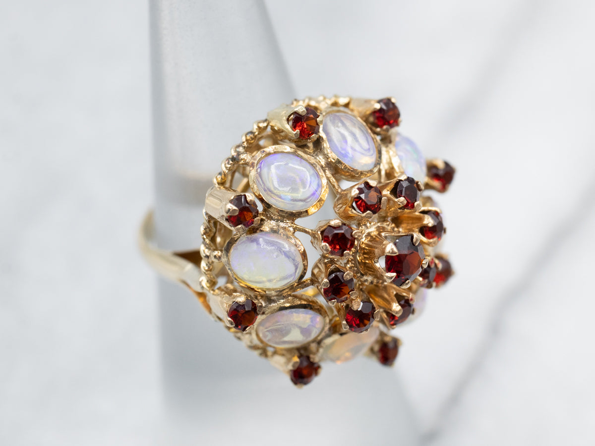 Anillo de cóctel con incrustaciones de ópalo y granate adornado