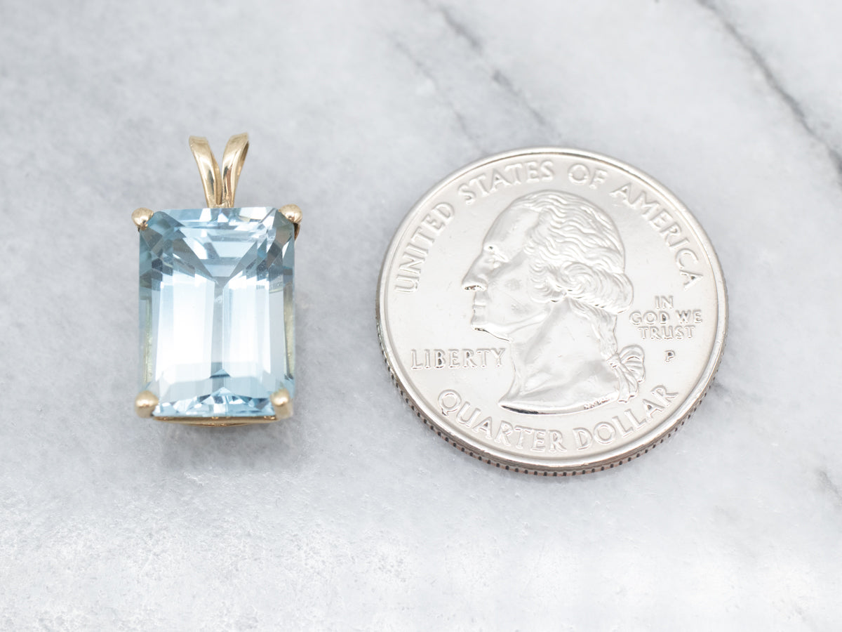 Sofisticado colgante con solitario de topacio azul y oro amarillo