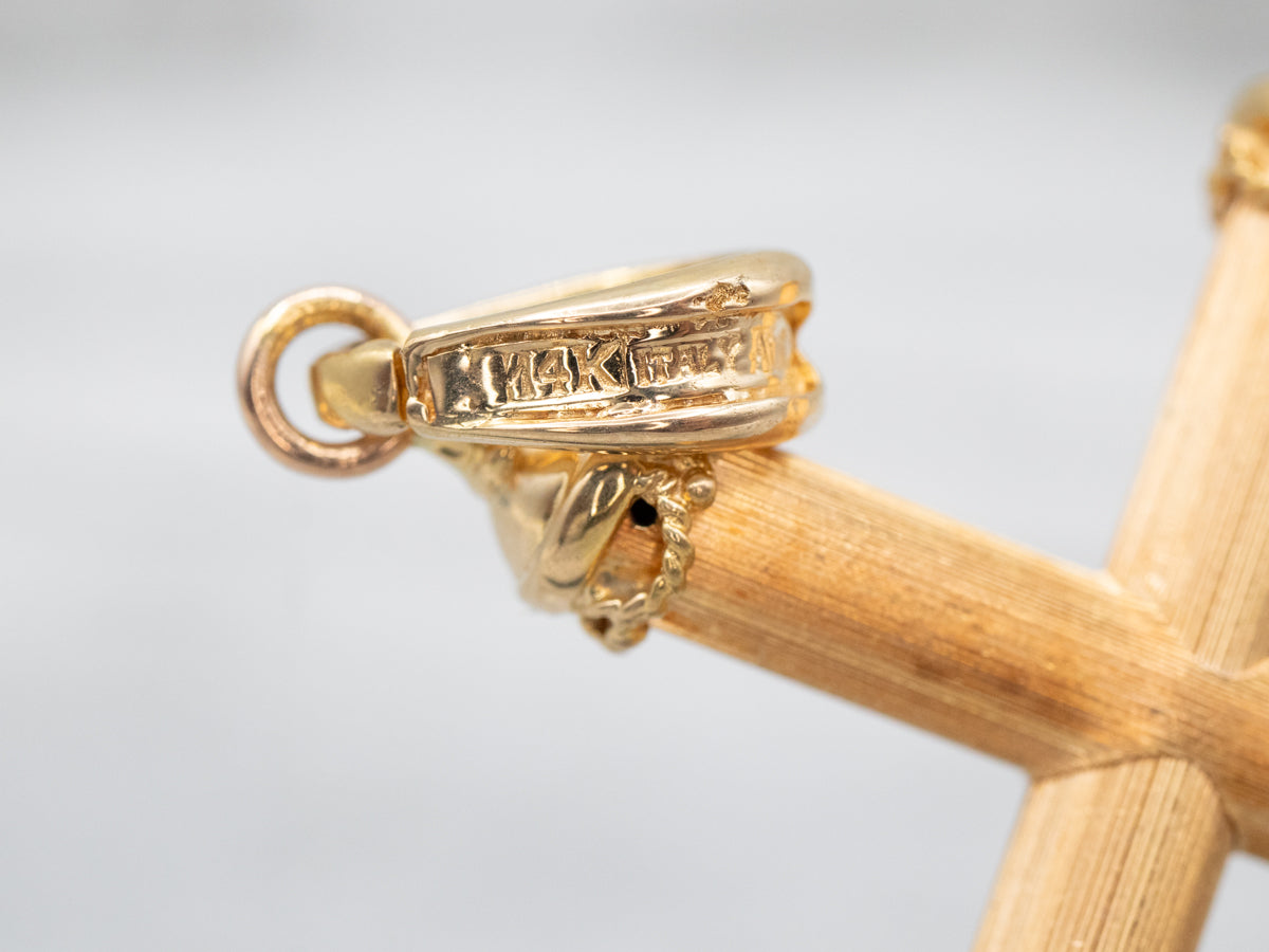 Cruz de oro texturizada con centro de turmalina rosa