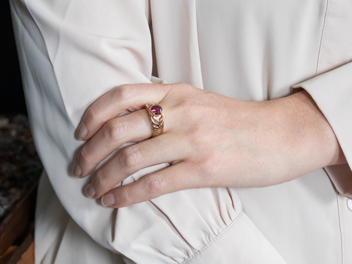 Anillo de oro amarillo con granate rodolita y detalles de diamantes