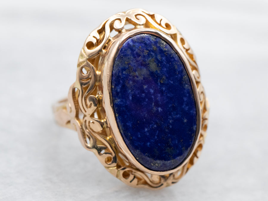 Yellow Gold Bezel Set Oval Cut Lapis Ring With Scrolling Frame