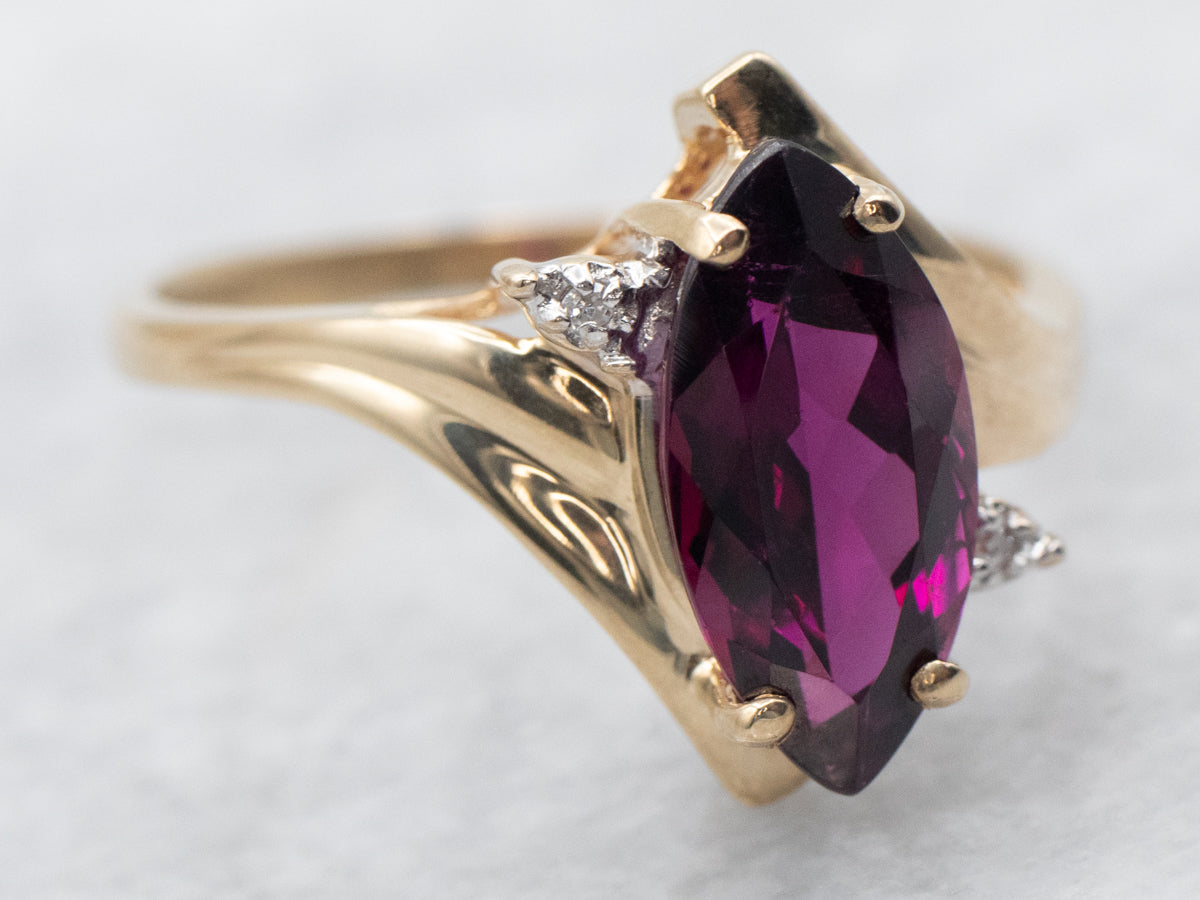 Anillo bypass de granate rodolita de talla marquesa en oro amarillo con detalles de diamantes