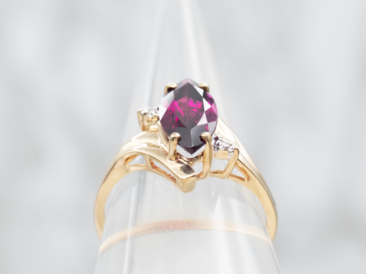 Anillo bypass de granate rodolita de talla marquesa en oro amarillo con detalles de diamantes