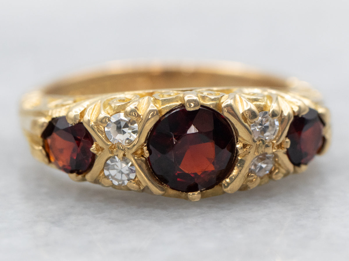 Anillo de oro amarillo con granate de talla redonda y detalles de diamantes