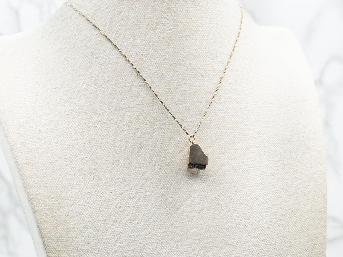 Charm de piano con apertura de esmalte blanco y negro en oro amarillo