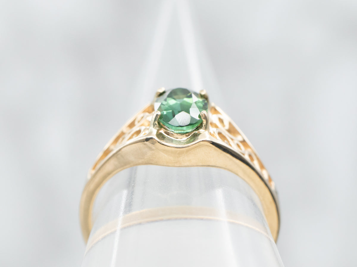 Yellow Gold Oval Cut Green Tourmaline Solitaire Ring with Pierced Scrolling Shoulders