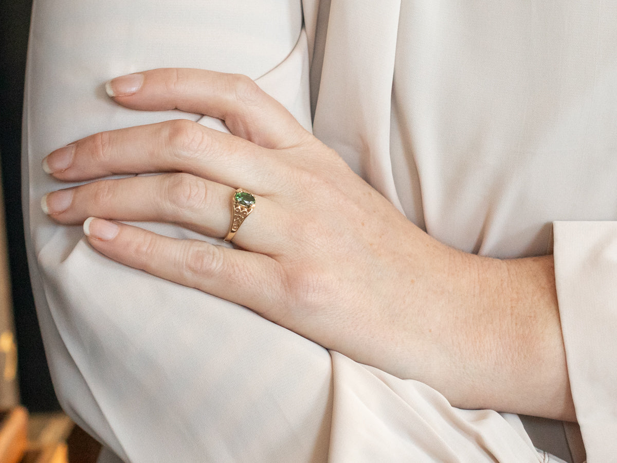 Yellow Gold Oval Cut Green Tourmaline Solitaire Ring with Pierced Scrolling Shoulders