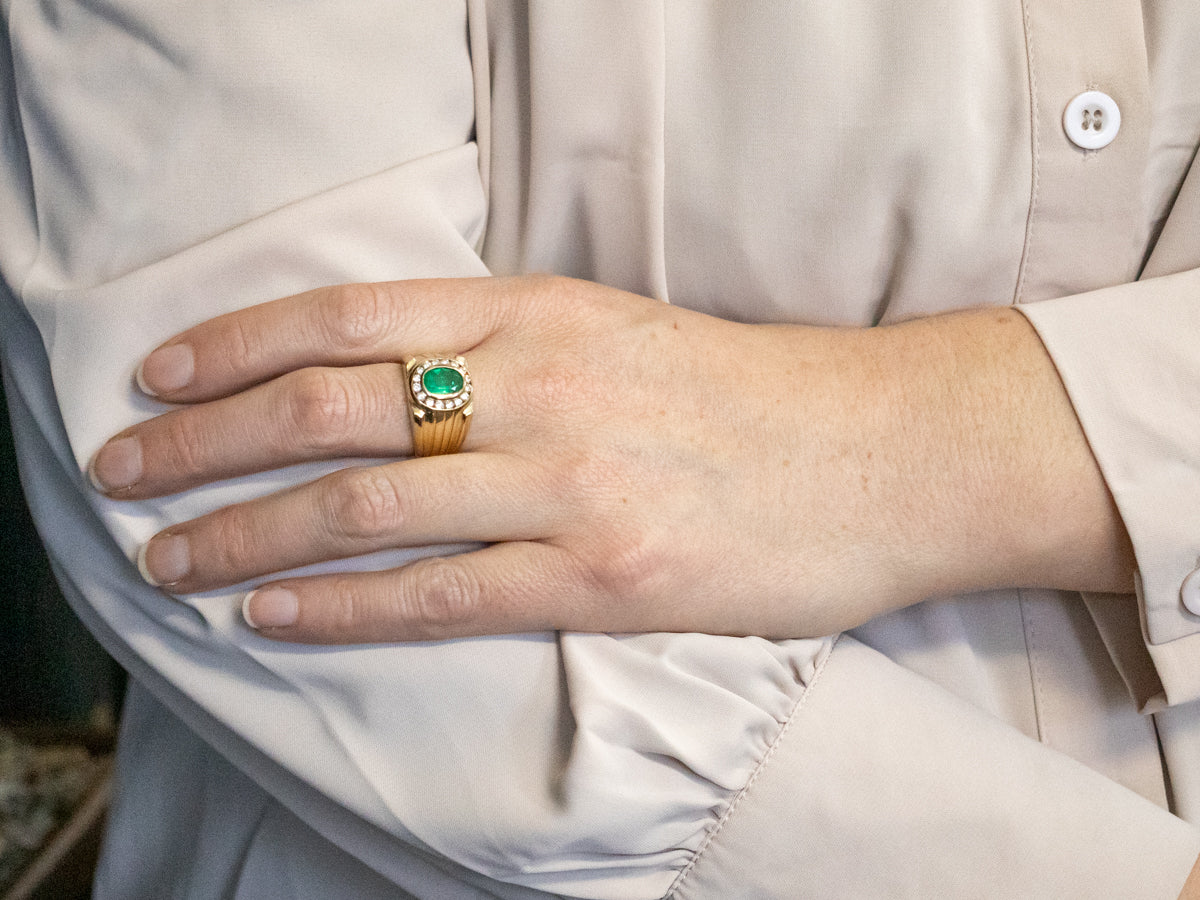 Yellow Gold Bezel Set Oval Cut Emerald Ring with Diamond Halo and Grooved Shoulders