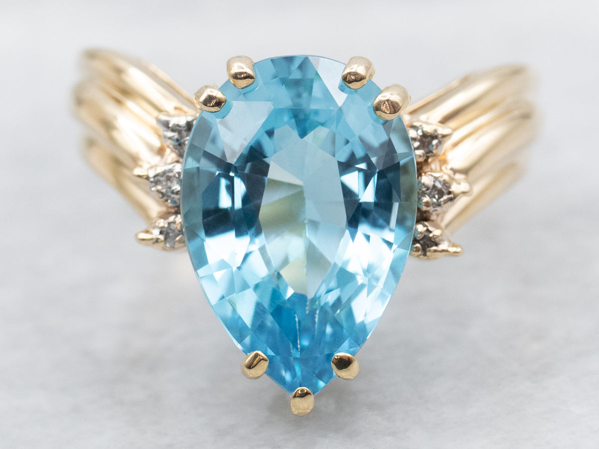 Anillo de oro amarillo con topacio azul de talla pera y detalles de diamantes