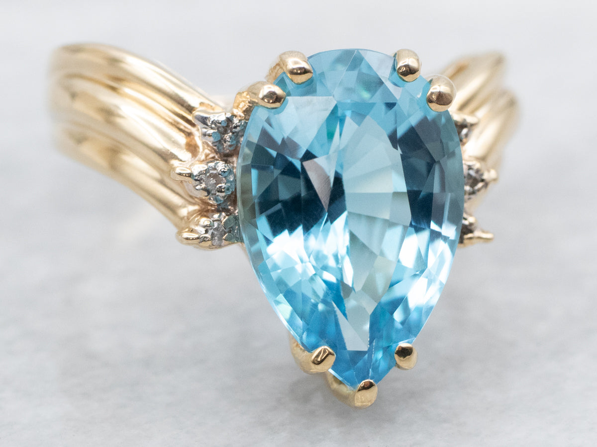 Anillo de oro amarillo con topacio azul de talla pera y detalles de diamantes