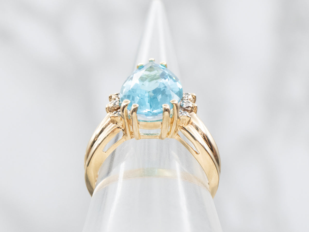 Anillo de oro amarillo con topacio azul de talla pera y detalles de diamantes