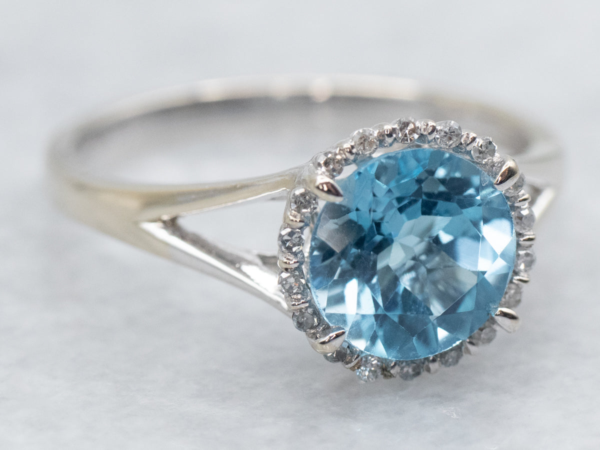 Anillo moderno de topacio azul con halo de diamantes