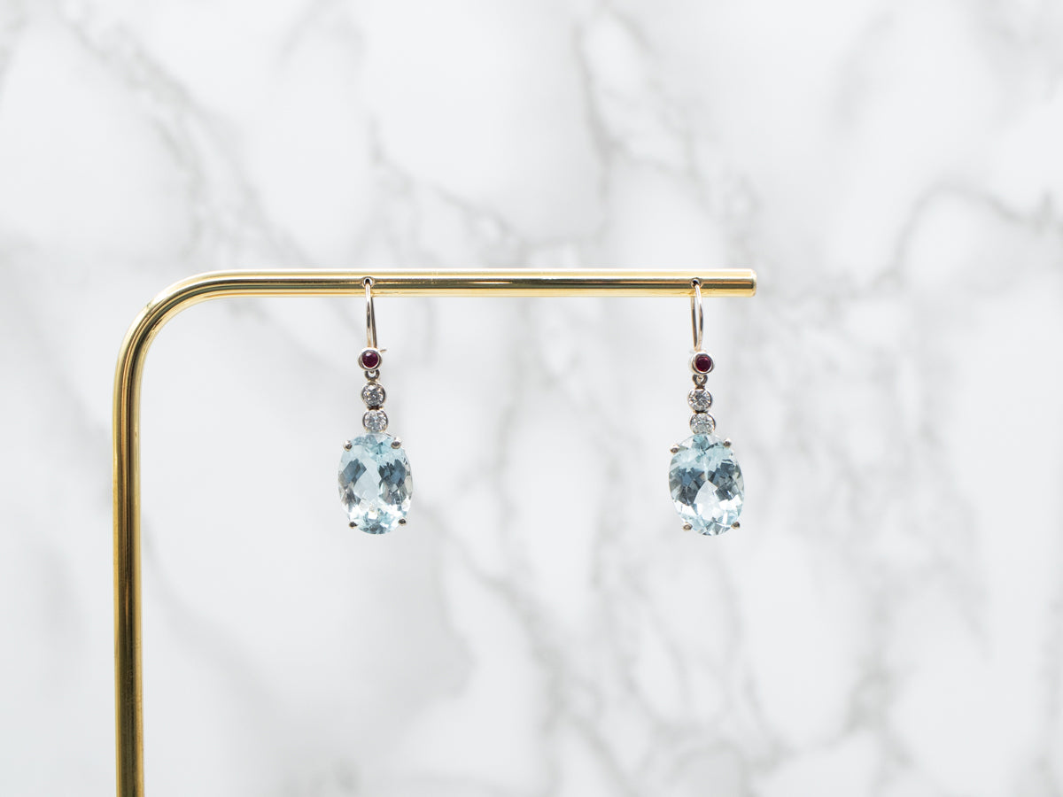 Aretes colgantes con topacio azul, diamantes y rubíes