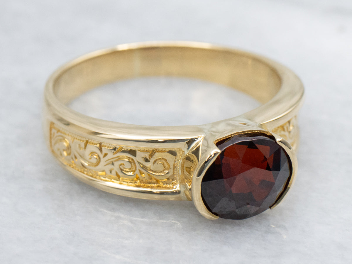 Men&#39;s East-to-West Set Garnet Scrolling Engraved Yellow Gold Solitaire Ring