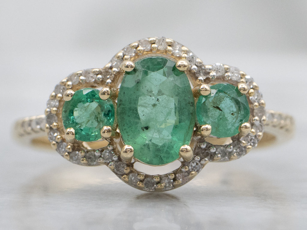 Vintage Gold Three-Stone Emerald and Diamond Halo Ring