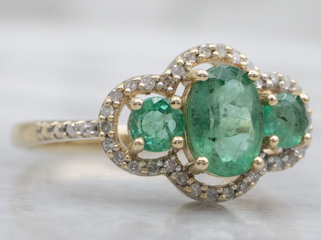 Vintage Gold Three-Stone Emerald and Diamond Halo Ring
