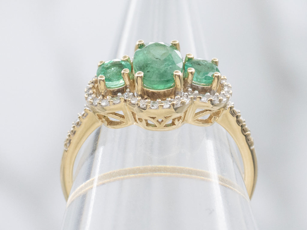 Vintage Gold Three-Stone Emerald and Diamond Halo Ring