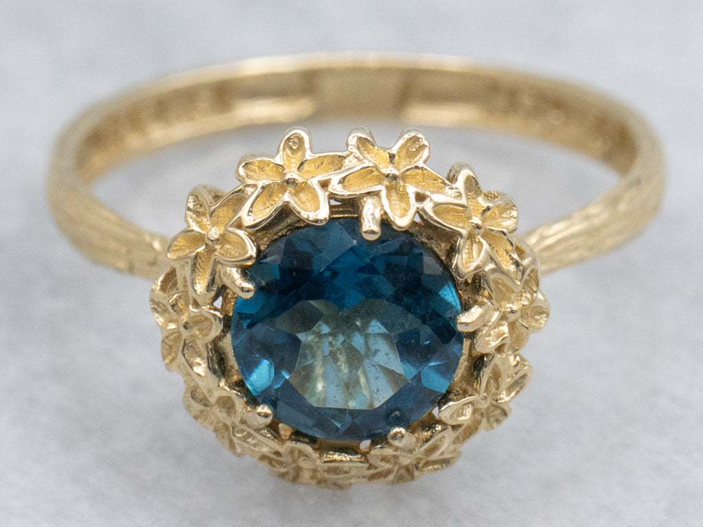 Blue Topaz Solitaire Ring in Golden Flower Halo