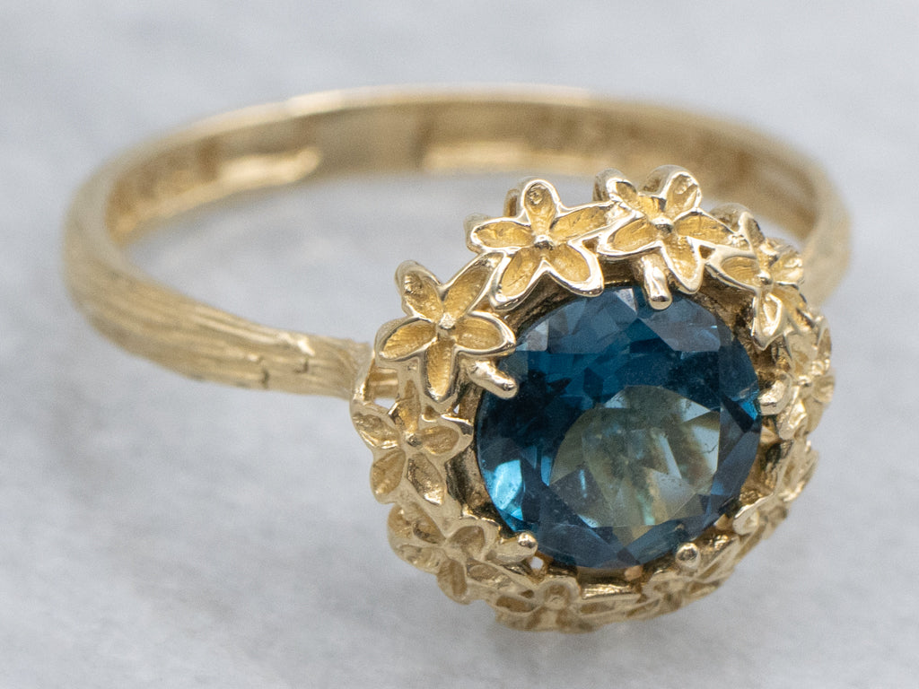 Blue Topaz Solitaire Ring in Golden Flower Halo