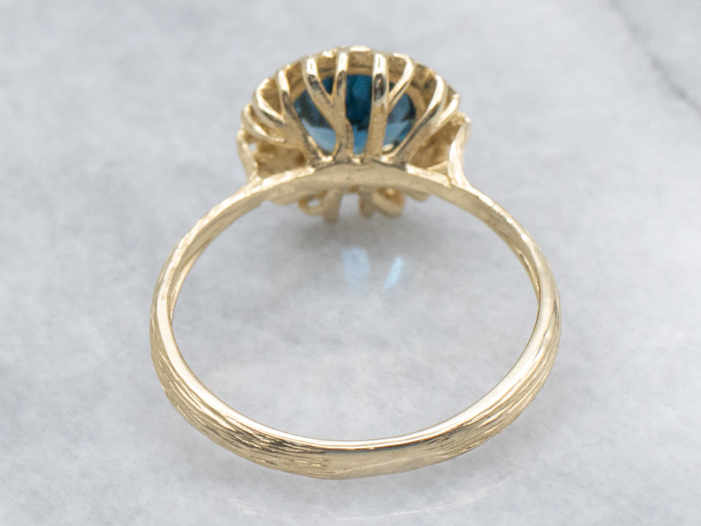 Blue Topaz Solitaire Ring in Golden Flower Halo