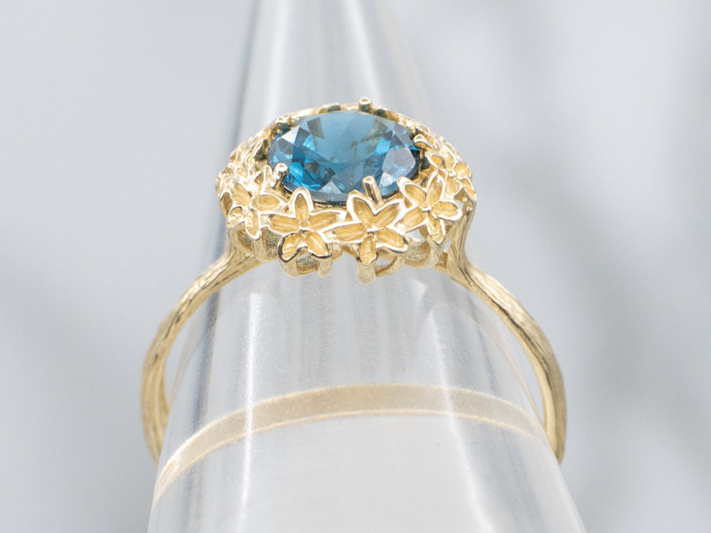 Blue Topaz Solitaire Ring in Golden Flower Halo