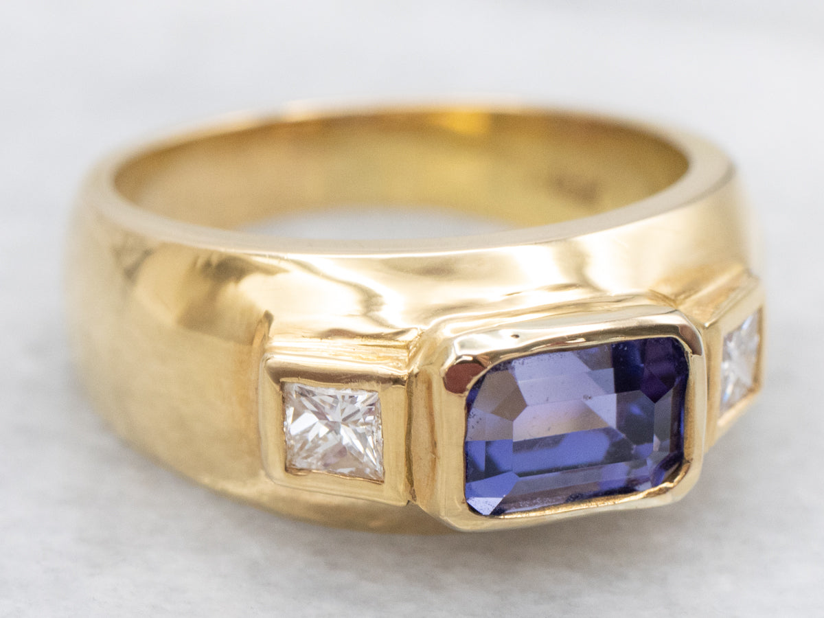 Anillo con detalles de diamantes y tanzanita de talla esmeralda en oro amarillo de 18 quilates