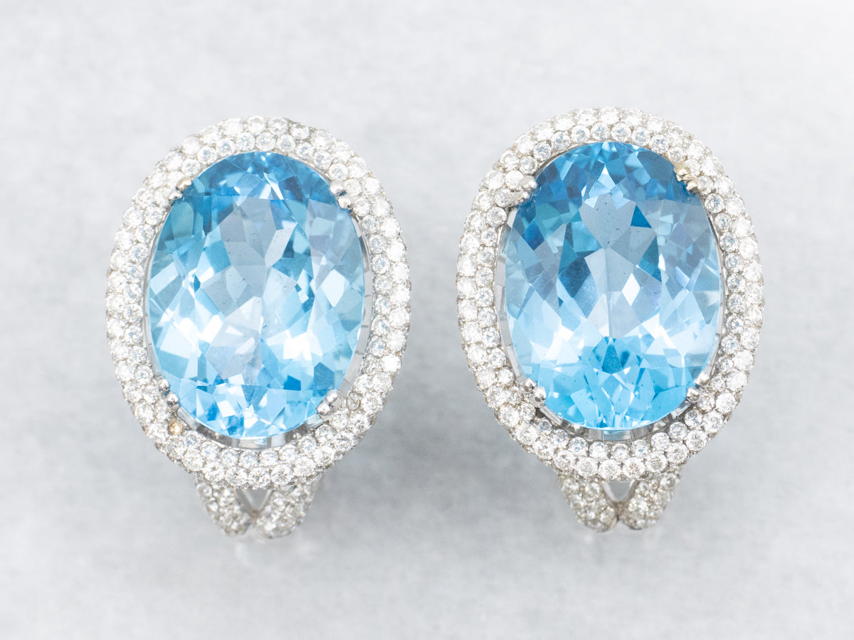 Aretes con halo de diamantes y topacio azul en oro blanco con respaldo Omega