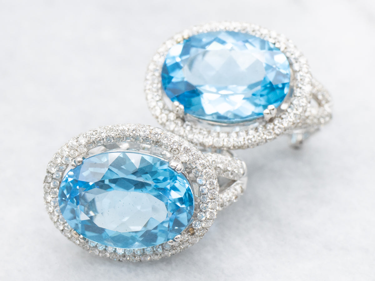 Aretes con halo de diamantes y topacio azul en oro blanco con respaldo Omega