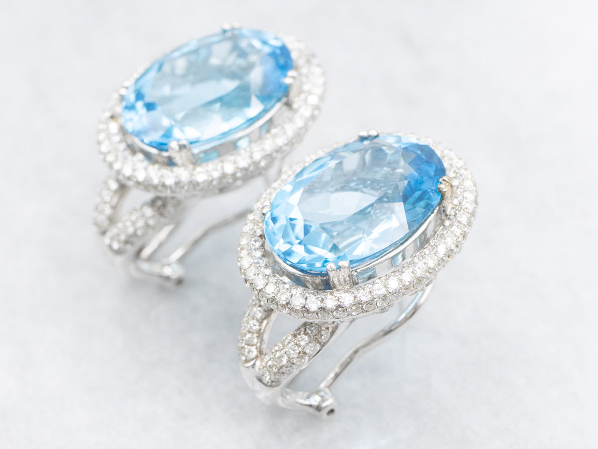 Aretes con halo de diamantes y topacio azul en oro blanco con respaldo Omega