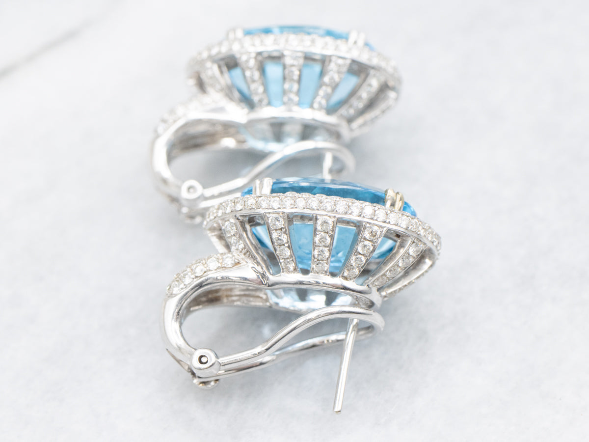 Aretes con halo de diamantes y topacio azul en oro blanco con respaldo Omega