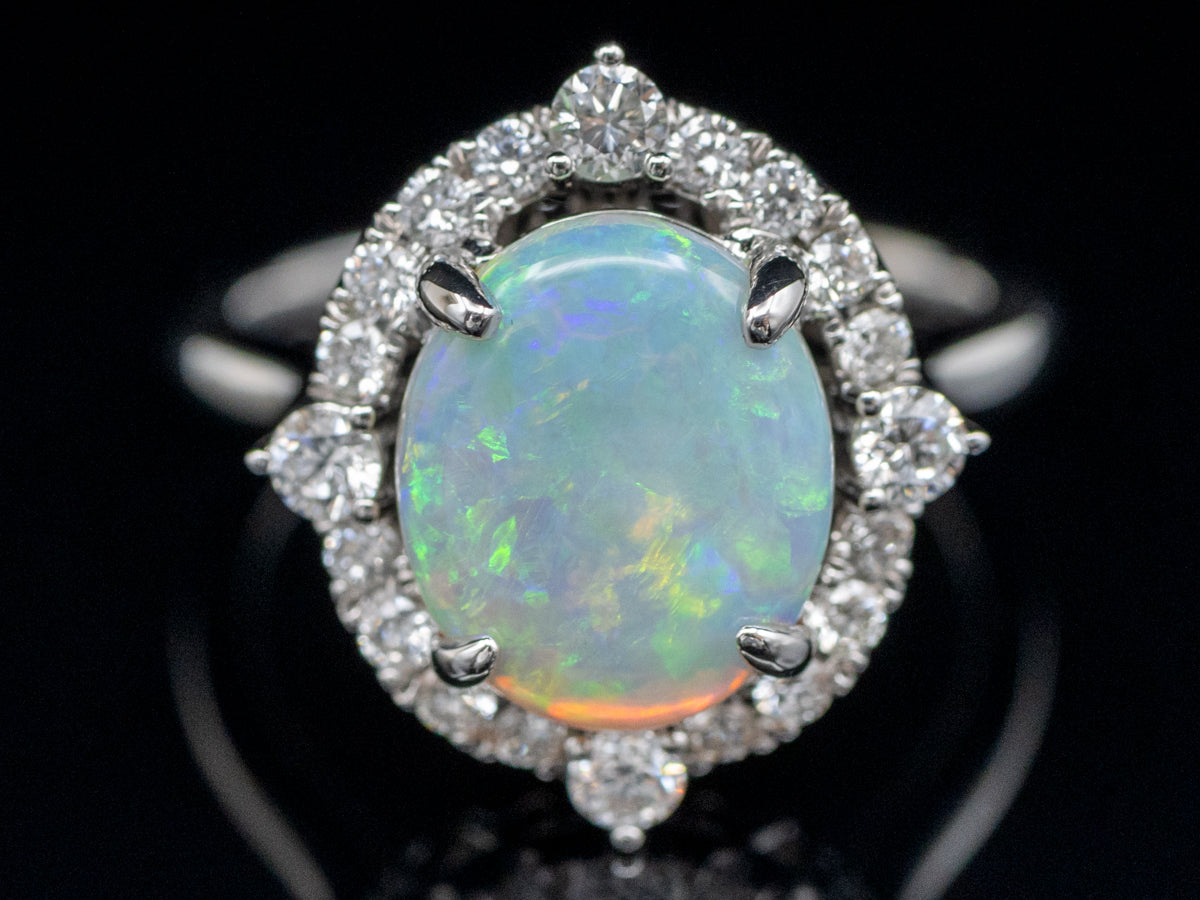 Anillo de cóctel con halo de diamantes y ópalo ovalado en oro blanco de 14 quilates