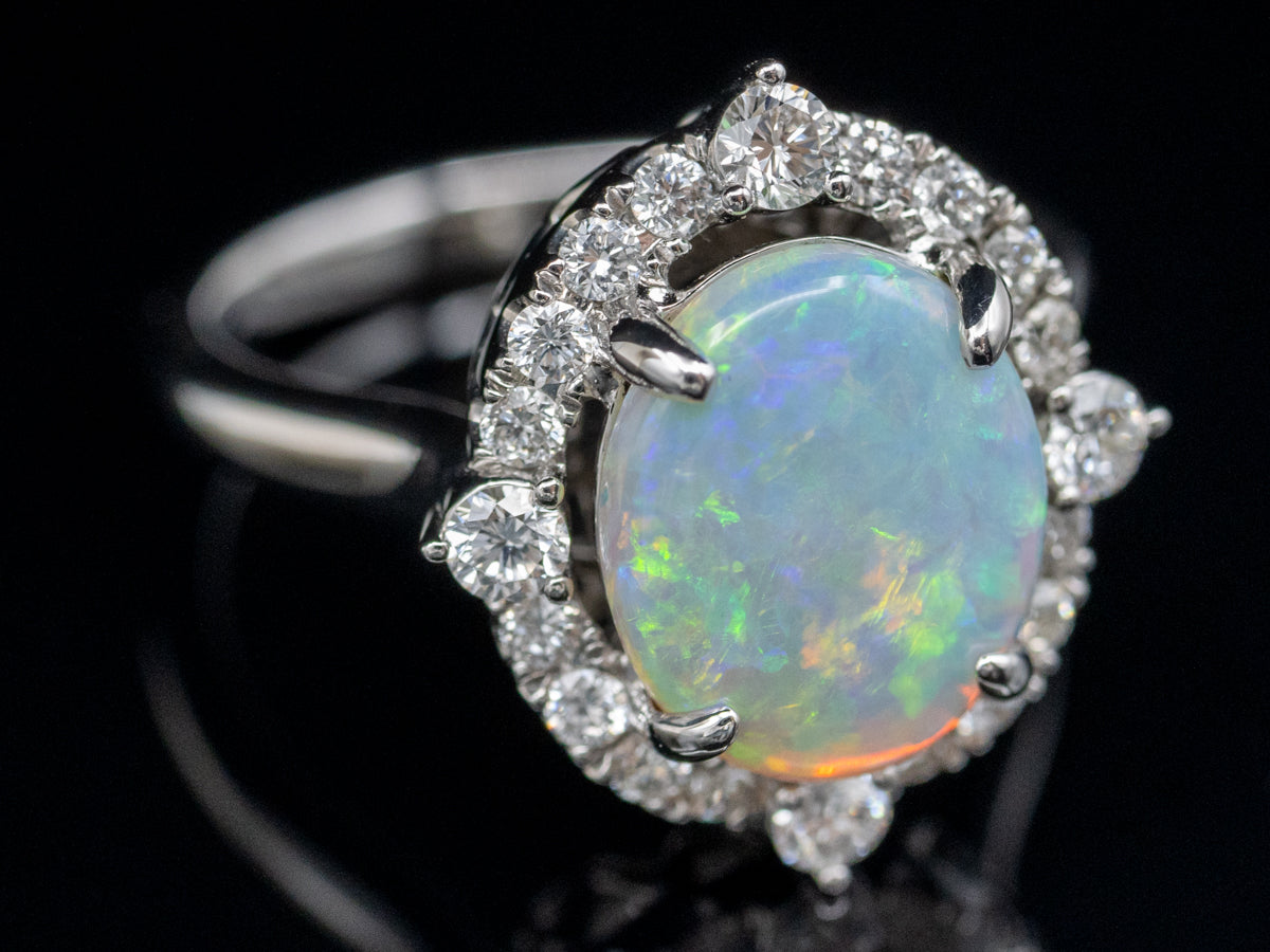 Anillo de cóctel con halo de diamantes y ópalo ovalado en oro blanco de 14 quilates
