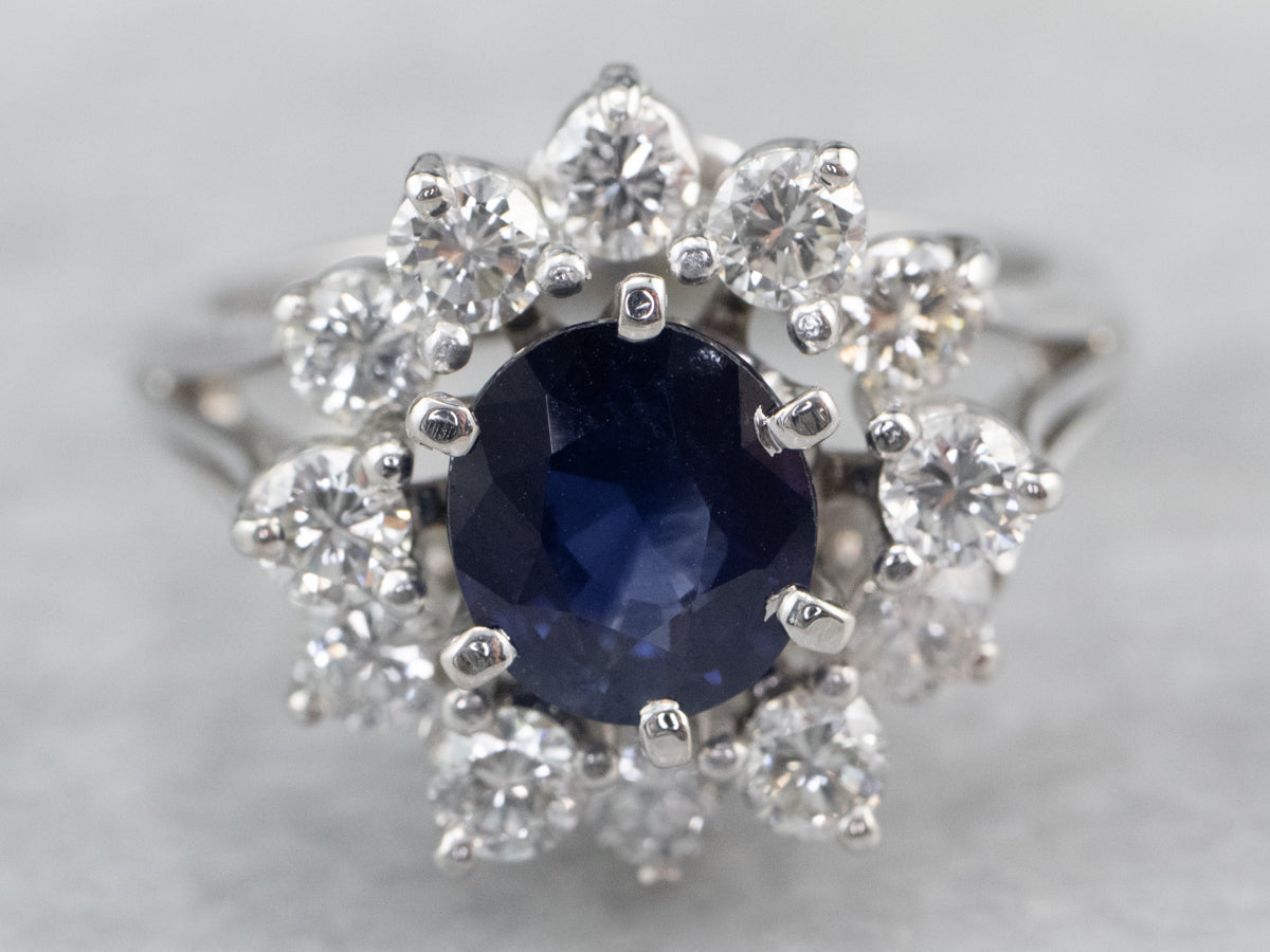 Anillo de compromiso de oro blanco con halo de diamantes y zafiro