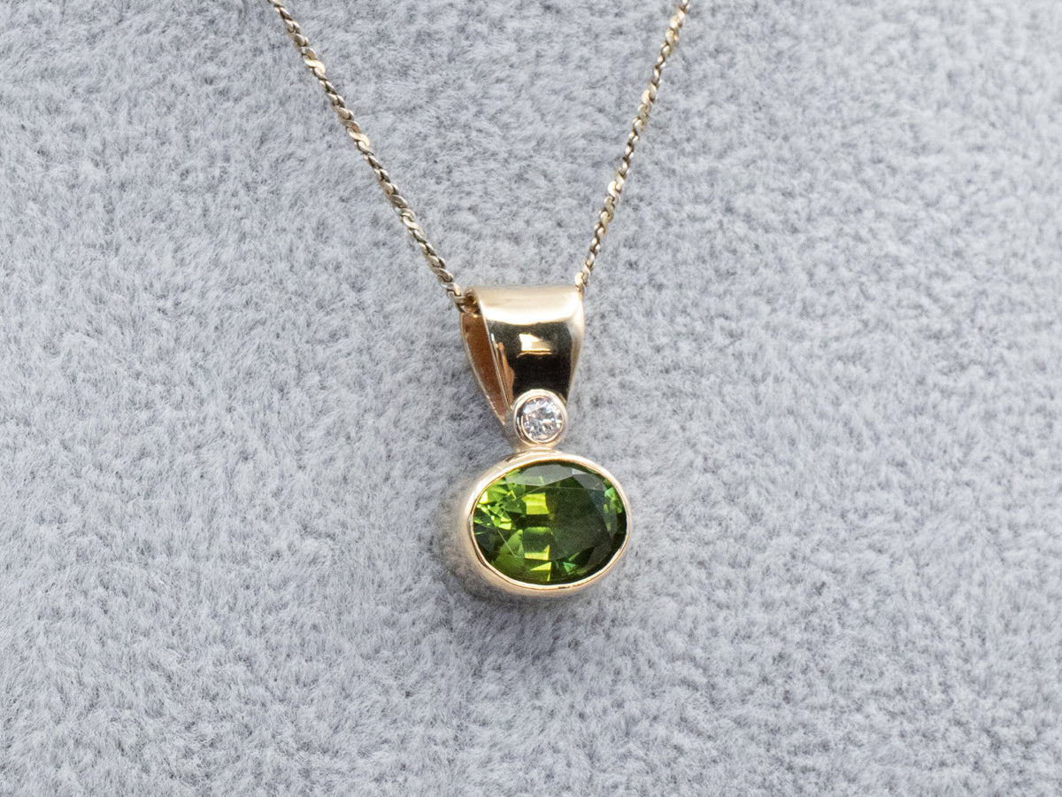 Elegante colgante dorado con turmalina verde y diamantes