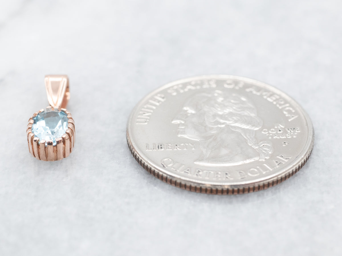 Colgante solitario de oro rosa con topacio azul brillante