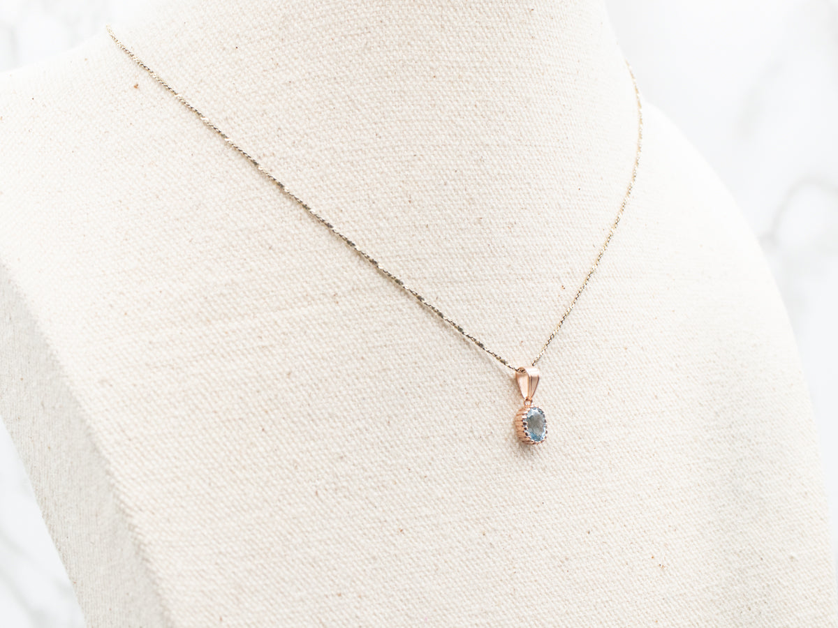 Colgante solitario de oro rosa con topacio azul brillante