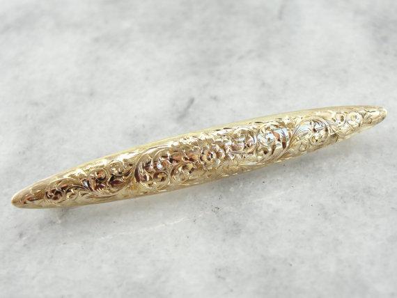 Broche de oro con motivo floral ornamentado grabado