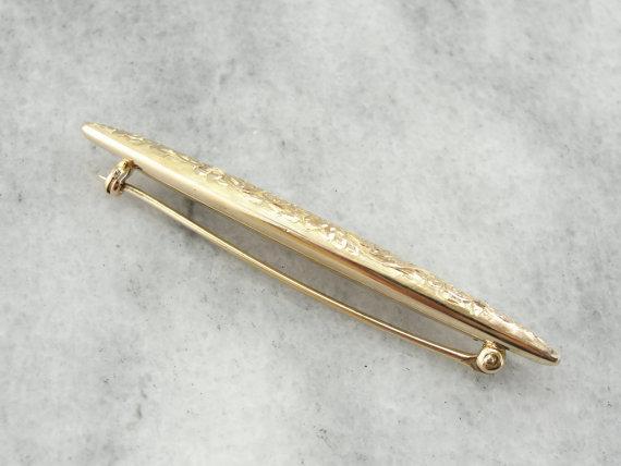 Broche de oro con motivo floral ornamentado grabado