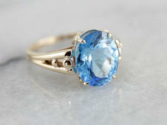 Brilliant Blue Topaz, Accented Split Shank Solitaire Ring in Yellow Gold